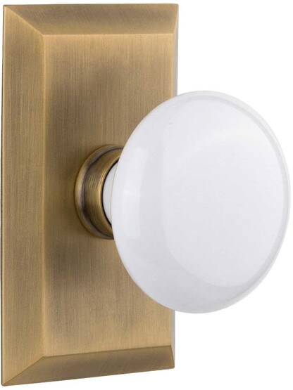 New York Rosette Door Set with White Porcelain Knobs in Antique Brass.